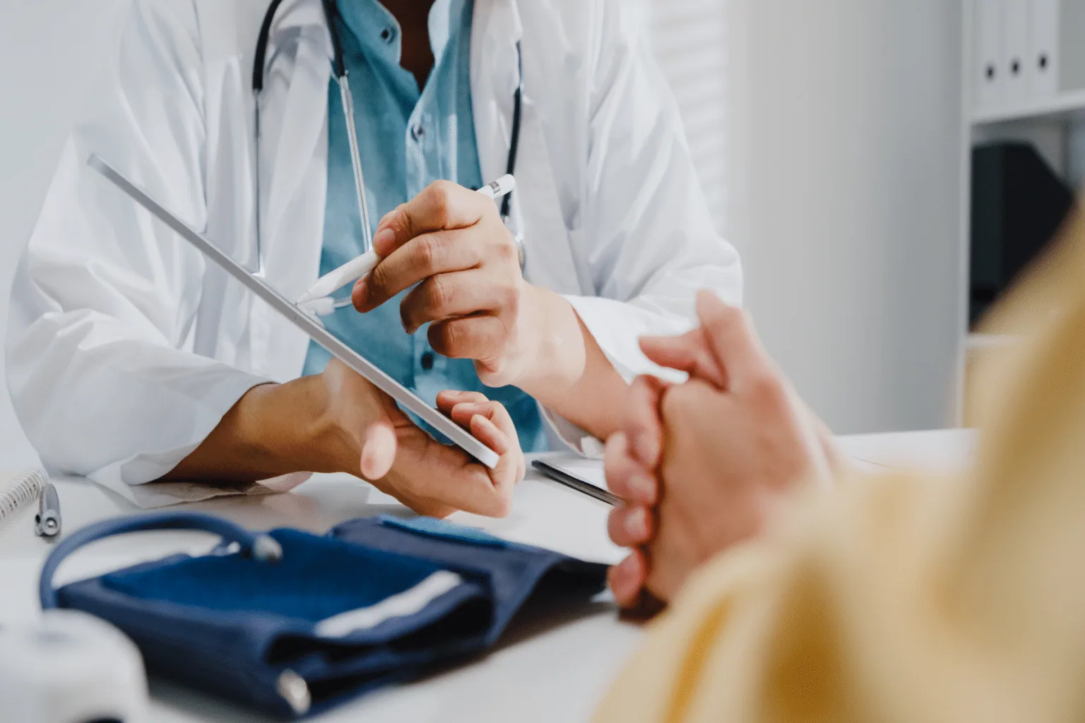 Dermatologist reviewing patient information on a tablet during a medical consultation