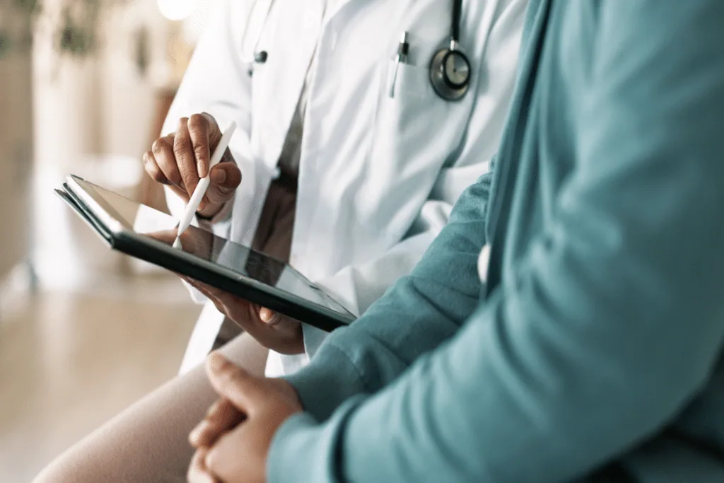 Dermatologist reviewing patient records on a tablet during a medical consultation