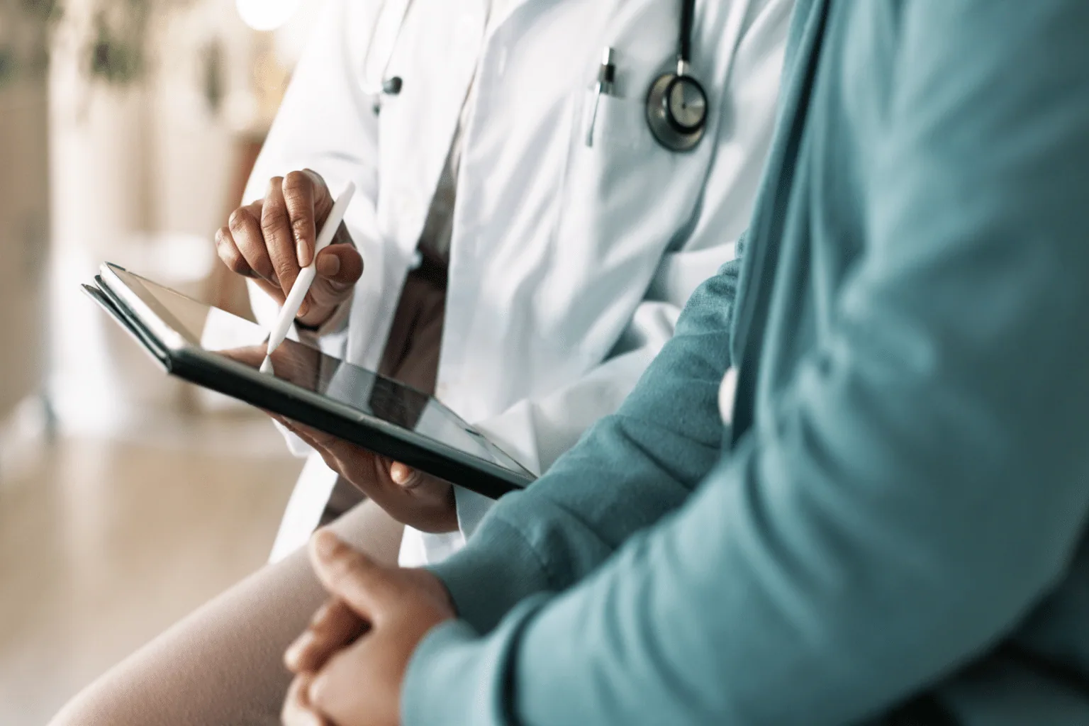 Dermatologist reviewing patient records on a tablet during a medical consultation