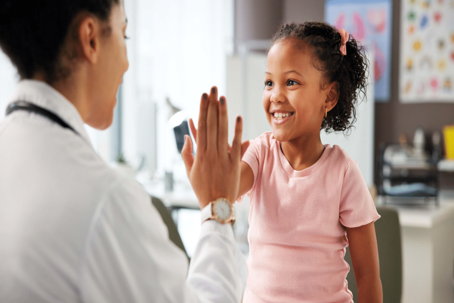 Dermatologist high-fiving a young patient during a medical consultation